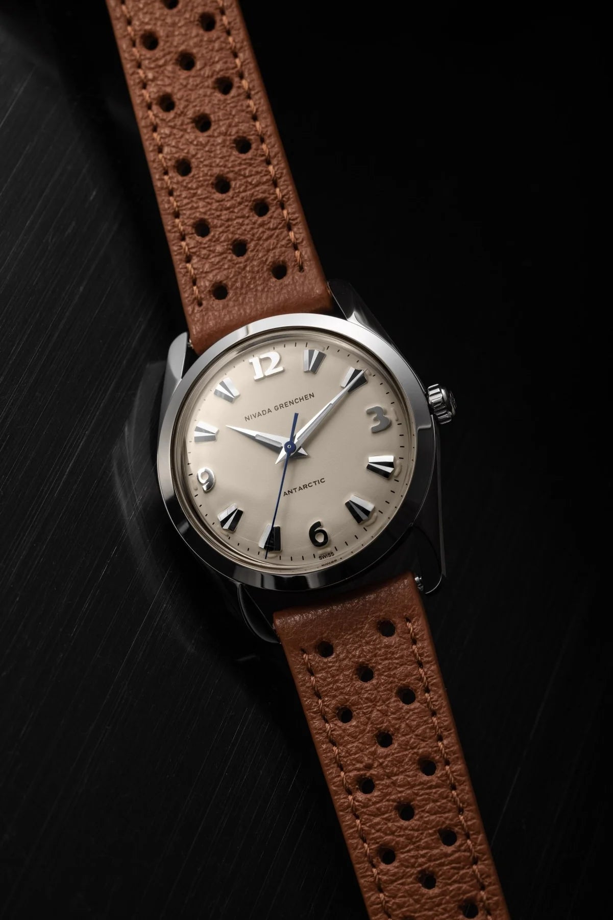 Watch with a brown leather strap on a black background Nivada Grenchen Antarctic Eggshell 